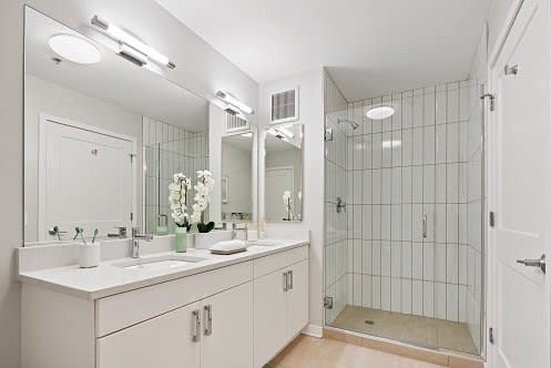 a bathroom with a large mirror and a walk in shower