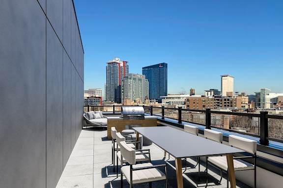 a rooftop patio with a table and chairs and the philadelphia skyline in the background