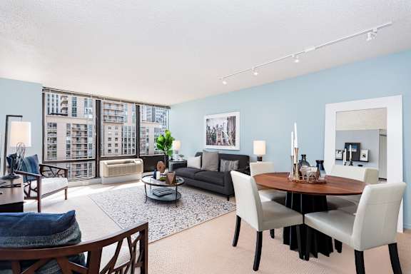 a living and dining room area with blue walls and a large window at Columbus Plaza, Chicago, 60601