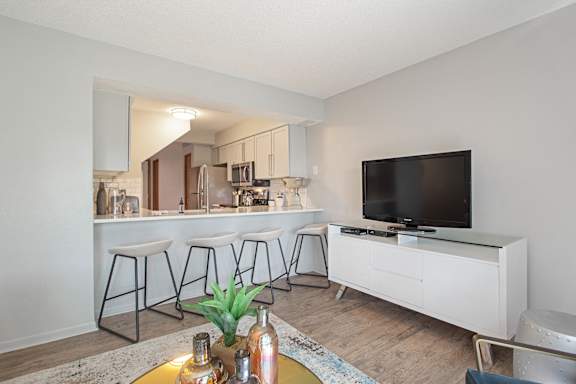 A modern living room with a bar area and a television at Seasons Villas, Woodbury, MN 55125