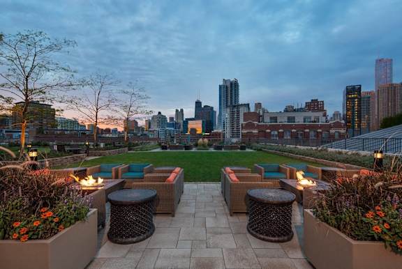 A park with a view of the city skyline at dusk.