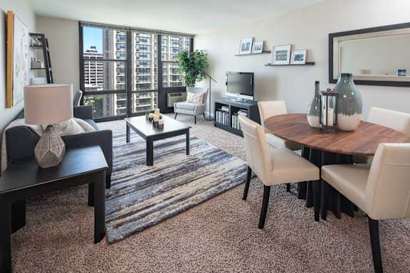 A modern living room with a wooden table and white chairs.