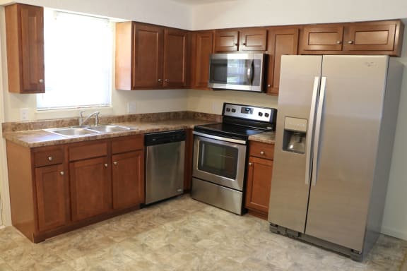 a kitchen with stainless steel appliances and wooden cabinets