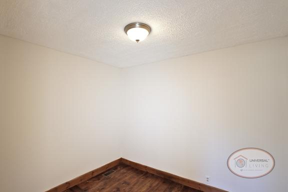 A room with hardwood flooring and white walls.