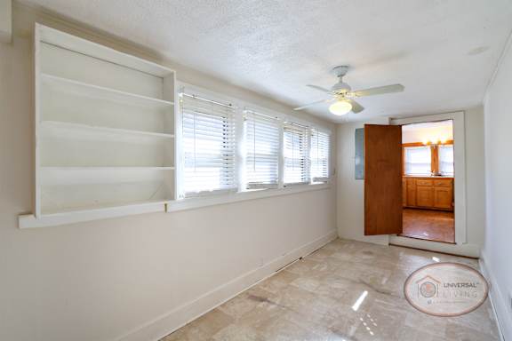 The laundry room with vinyl floors, washer and dryer hookups, a window, and white cabinets.