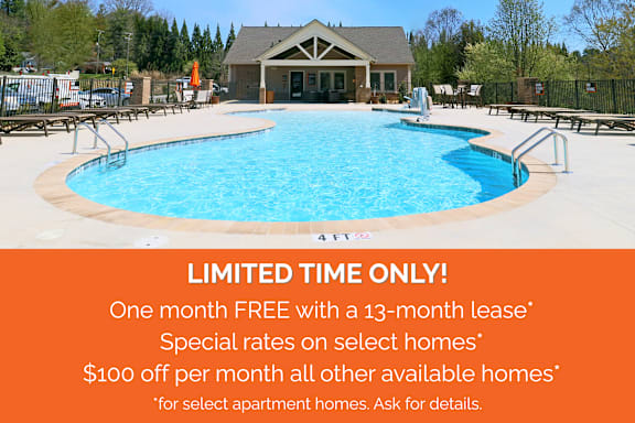 A pool with a building in the background and a sign offering a free month with a lease.