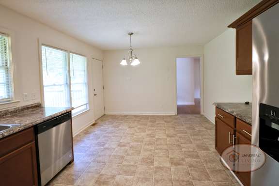 A spacious kitchen with dining area and large windows.