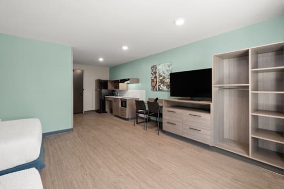 A living room with a television, a chair, and a cabinet.