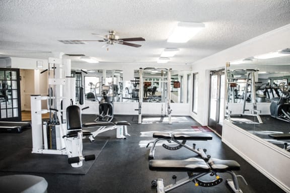 Fitness center with exercise equipment and mirrors at Cantera Apartments, El Paso, Texas