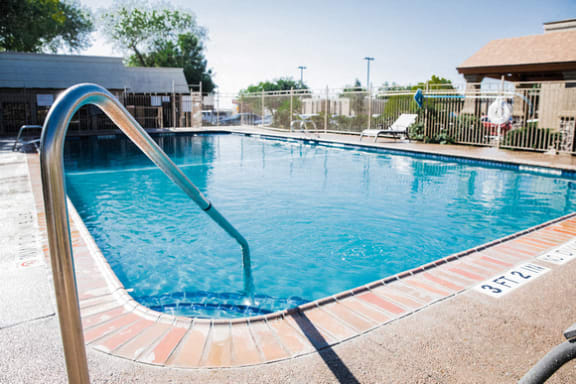 Swimming pool with handrail and patio seating at Cantera Apartments, Texas