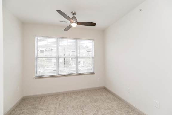 A room with a ceiling fan and a window with blinds at 1701 North Apartment Homes Apartments, Chapel Hill, NC, 27514