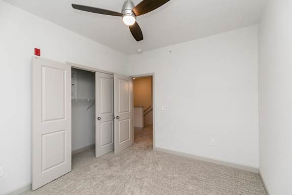 A room with a ceiling fan and three doors at 1701 North Apartment Homes Apartments, Chapel Hill, NC