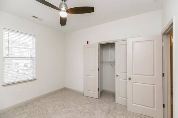 A room with a ceiling fan and a window with blinds at 1701 North Apartment Homes Apartments, Chapel Hill, NC, 27514