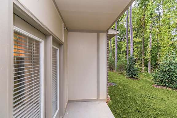 A balcony with a view of a green forest at 1701 North Apartment Homes Apartments, Chapel Hill