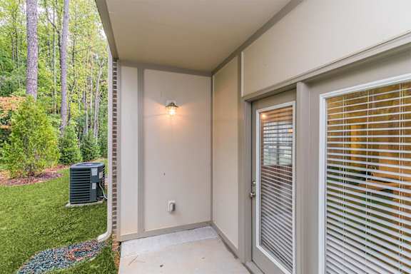 A patio area with a sliding door and a window with blinds at 1701 North Apartment Homes Apartments, Chapel Hill, 27514