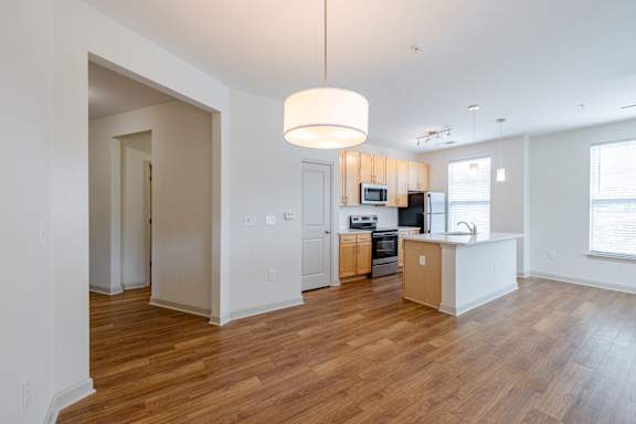 A kitchen with a wooden floor and white walls. at 1701 North Apartment Homes Apartments, North Carolina
