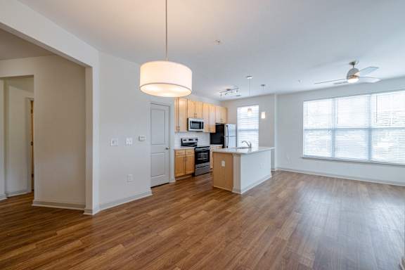 A kitchen with a wooden floor and a ceiling fan at 1701 North Apartment Homes Apartments, Chapel Hill