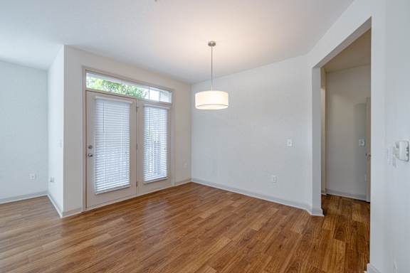 A room with wooden floors and a window with blinds at 1701 North Apartment Homes Apartments, North Carolina, 27514