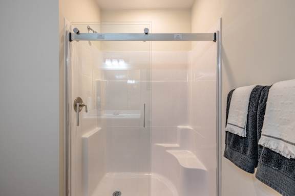 A glass shower stall with a towel hanging on the wall at 1701 North Apartment Homes Apartments, Chapel Hill, NC, 27514
