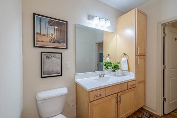 A bathroom with a toilet, sink, and a mirror at 1701 North Apartment Homes Apartments, Chapel Hill, 27514