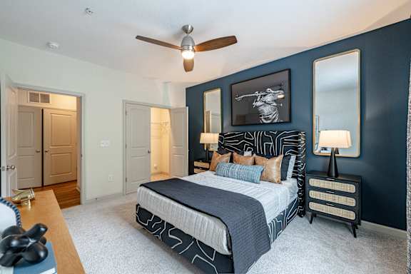 A bedroom with a bed, nightstand, and a ceiling fan at 1701 North Apartment Homes Apartments, North Carolina