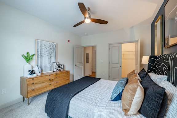 A bedroom with a bed, dresser, and ceiling fan at 1701 North Apartment Homes Apartments, Chapel Hill, North Carolina