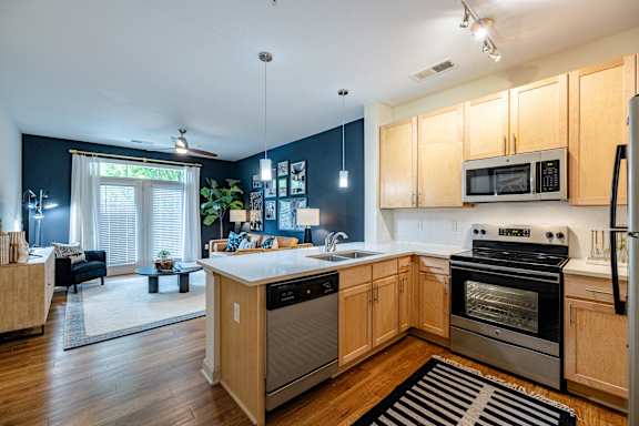 A kitchen with wooden cabinets and stainless steel appliances at 1701 North Apartment Homes Apartments, Chapel Hill, NC