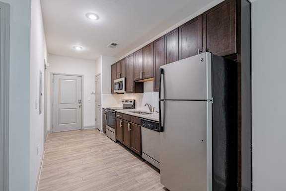 A kitchen with a refrigerator, microwave, and oven at 1701 North Apartment Homes Apartments, Chapel Hill, North Carolina