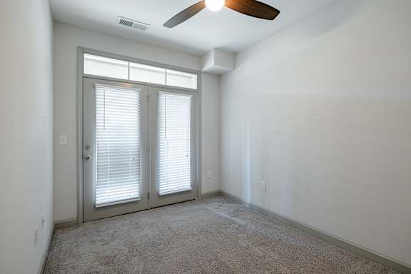 A room with a ceiling fan and a sliding door at 1701 North Apartment Homes Apartments, North Carolina, 27514