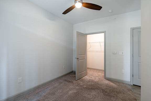 A room with a ceiling fan and carpeted floor at 1701 North Apartment Homes Apartments, Chapel Hill