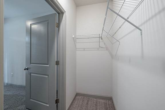 A grey door is open to a white wall with a shelf at 1701 North Apartment Homes Apartments, North Carolina