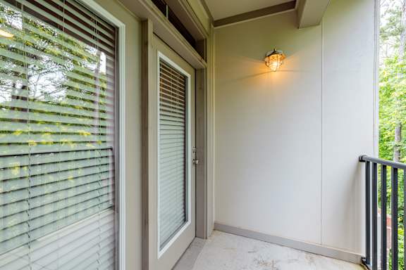 A white door with a window to the left and a light on the wall to the right at 1701 North Apartment Homes Apartments, Chapel Hill, North Carolina