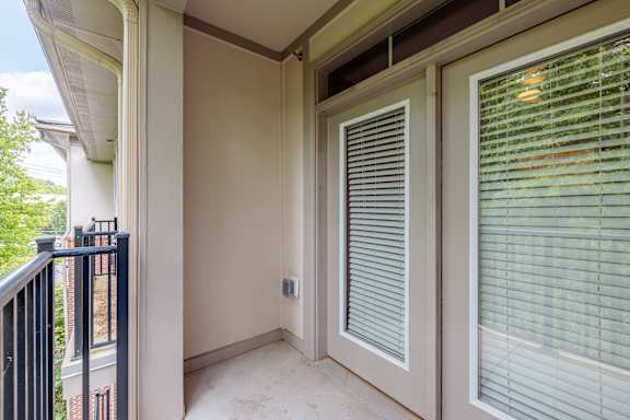 A balcony with a sliding door and a window with blinds at 1701 North Apartment Homes Apartments, Chapel Hill