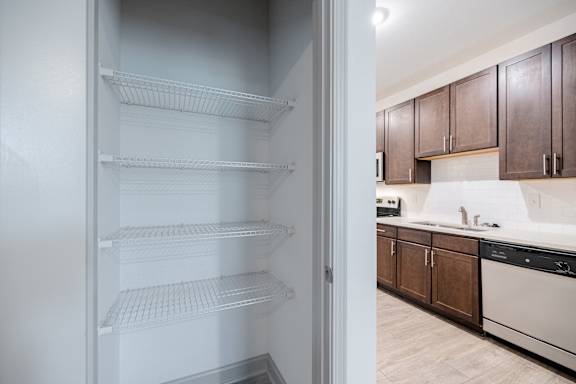 Empty white shelves in a kitchen at 1701 North Apartment Homes Apartments, North Carolina