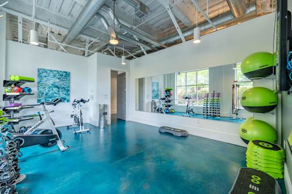 A gym with exercise equipment and a blue floor at 1701 North Apartment Homes Apartments, Chapel Hill, 27514