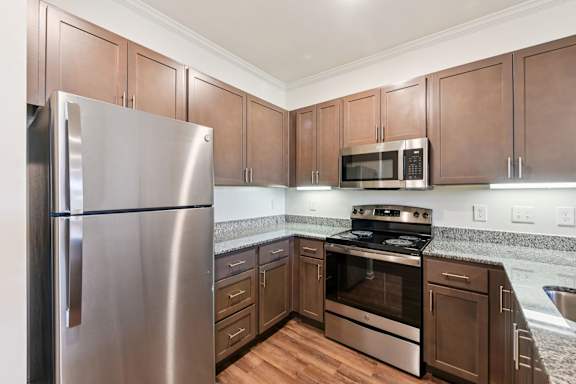 A kitchen with a stainless steel refrigerator and wooden cabinets  at Ardmore at the Trail, Indian Trail, 28079