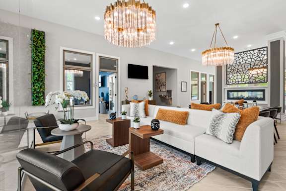A modern living room with a white sofa and a large chandelier.