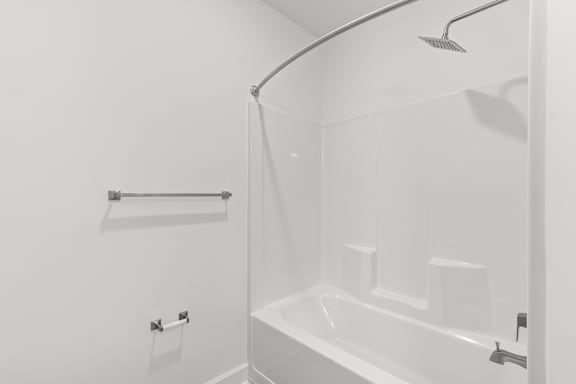 A white bathroom with a shower and a bathtub.