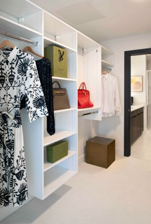 a walk in closet with white shelving and a black and white dress at 220 Meridian in Indianapolis, IN 46204