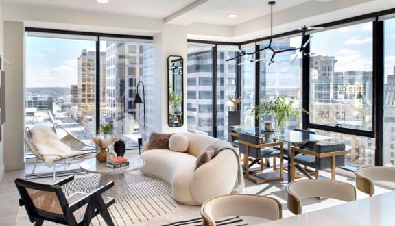 a living room with a white couch and a table with chairs and large windows at 220 Meridian in Indianapolis, IN 46204