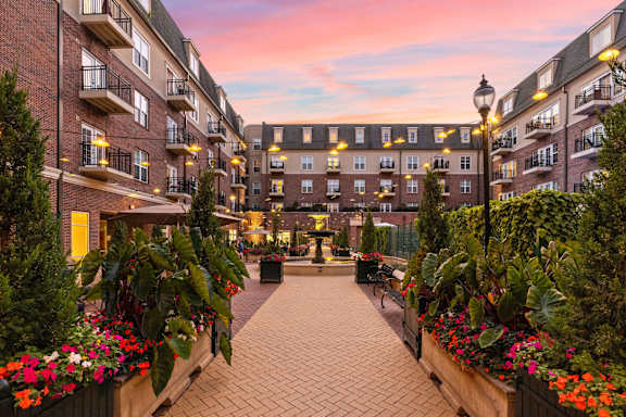 A courtyard with a brick walkway and flower boxes on the buildings at Sophia Square Apartments, Carmel