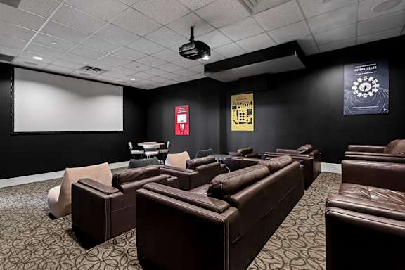 A dark room with a screen and chairs at Sophia Square Apartments, Carmel, Indiana