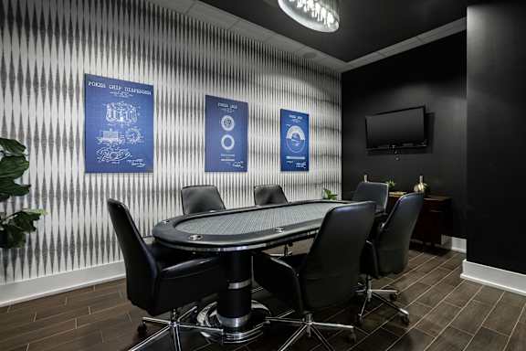 A conference room with a table surrounded by chairs and posters on the wall at Sophia Square Apartments, Carmel, IN, 46032