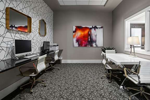 A room with a patterned wallpaper and a large abstract painting on the wall at Sophia Square Apartments, Carmel, IN
