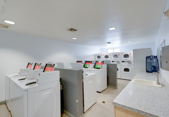 a laundry room with washers and dryers at Helix at University Village, Pomona, 91766
