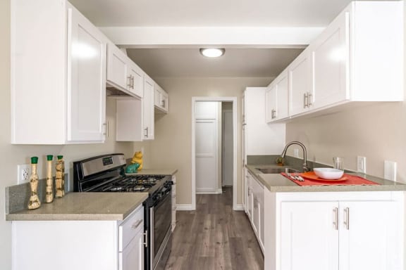 a kitchen with white cabinets and a black stove top oven at Mountainview Venture, Covina