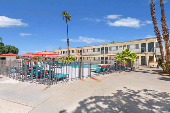 our apartments have a pool and patio with chairs and umbrellas at Sunnymead Apts Apartments, California, 92553
