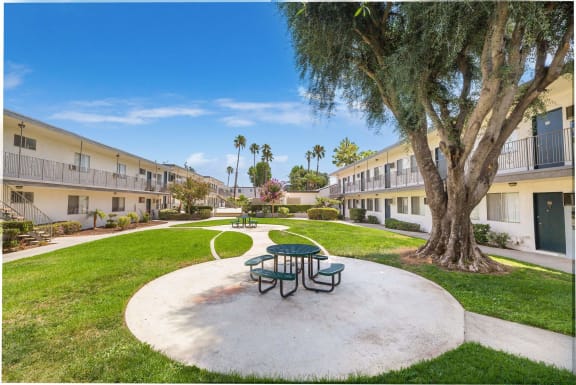 a park with a picnic table and a tree in a courtyard at Sunnymead Apts Apartments, Moreno Valley, CA