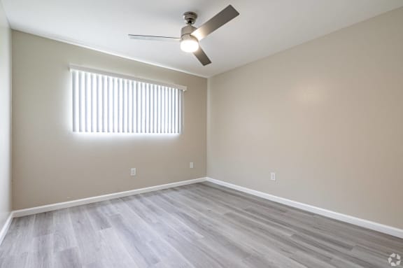 an empty living room with wood floors and a ceiling fan at Huntington Terrace North Senior, California