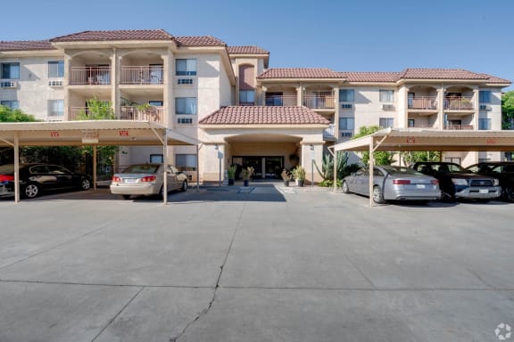 an empty parking lot in front of an apartment building with cars parked at Flamingo Garden Senior Apts, El Monte, 91732